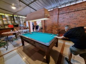 a man playing pool in a room with a pool table at Hostal Jardín de Luque in San Lorenzo