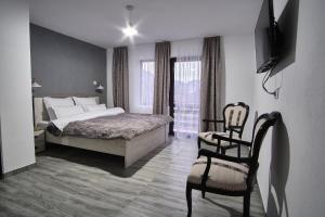 フンドゥ・モルドベイにあるCasa cu Tihnaのベッドルーム1室(ベッド1台、椅子付)