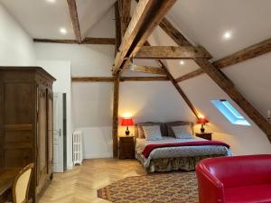 a bedroom with a bed and a red chair at Casa La Palma Le 48 in Soissons