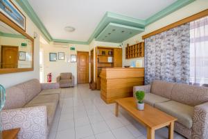 a living room with a couch and a table at Dias Hotel Apartments in Agia Marina Nea Kydonias