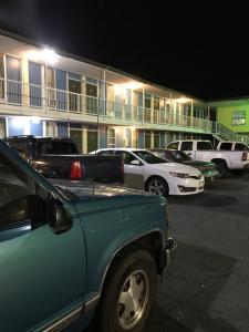 un grupo de autos estacionados frente a un motel en Hope Inn en Lenox