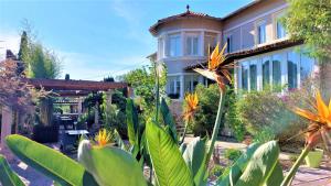 uma casa com muitas plantas à frente dela em Hotel Les Jardins de Bormes em Bormes-les-Mimosas