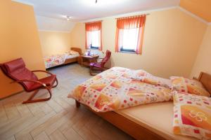 a bedroom with two beds and a table and chairs at Okrepčevalnica Kurn'k in Cerkno