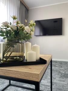 stół ze świecami i wazon kwiatów w obiekcie Apartament Senator 115m2 w mieście Katowice