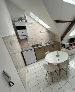 a kitchen with a white table and white chairs at Les cerisiers in Bavans
