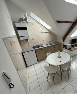 a kitchen with a white table and white chairs at Les cerisiers 