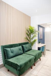 um sofá verde num quarto com uma mesa em Big House Next to Brighton Beach Sleep 16 I HENS PARTY & STAG DOS WELCOME em Brighton & Hove