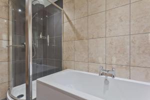 un baño con bañera y ducha en No 6 The Forge Coniston, en Coniston 8 fotos más