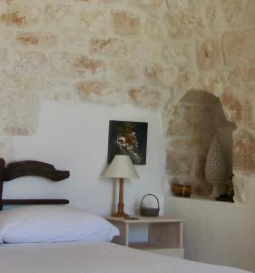 - une chambre avec un lit et une table avec une lampe dans l'établissement Casa della Scrittrice, à Ostuni