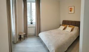 Schlafzimmer mit einem Bett und einem Fenster in der Unterkunft Balance appartment - Le Locle in Le Locle