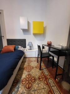 1 dormitorio con cama, escritorio y mesa en ALFIERI Guest House, en Vercelli