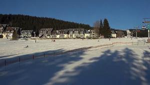 a beach with people playing in the snow at Apartman M5 Horní Mísečky in Horni Misecky