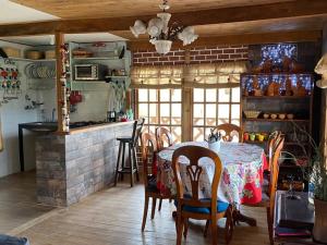 Refugio Aralar EcoLodge في Toca: مطبخ وغرفة طعام مع طاولة وكراسي