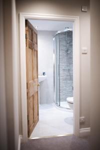 uma casa de banho com um chuveiro e uma porta de vidro em Howgill House Barn em Draughton