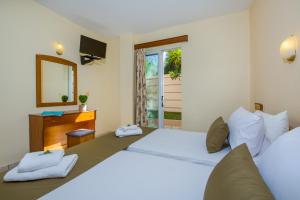 a bedroom with a large bed and a mirror at Dias Hotel Apartments in Agia Marina Nea Kydonias +29 photos