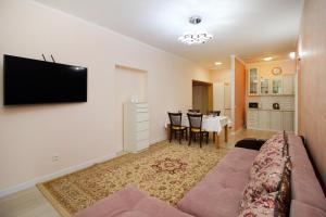 uma sala de estar com um sofá e uma televisão de ecrã plano em ЖК Верный, 3-комнатная квартира, рядом с верхней Мегой, вдоль речки em Almaty