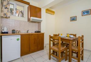 a kitchen with a table and a sink and a refrigerator at Dias Hotel Apartments in Agia Marina Nea Kydonias