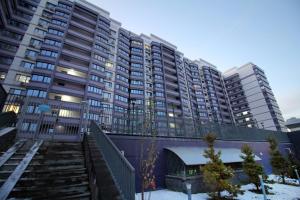 ein großes Apartmenthaus mit einer Treppe davor in der Unterkunft ЖК Верный, 3-комнатная квартира, рядом с верхней Мегой, вдоль речки in Almaty