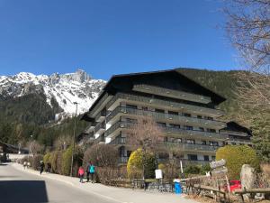 un grand bâtiment avec une montagne en arrière-plan dans l'établissement Appartement Chamonix-Mont-Blanc, 2 pièces, 4 personnes - FR-1-507-26, à Chamonix-Mont-Blanc