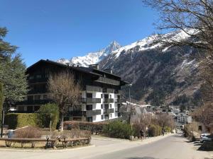 un bâtiment situé sur le côté d'une route avec une montagne dans l'établissement Appartement Chamonix-Mont-Blanc, 2 pièces, 4 personnes - FR-1-507-26, à Chamonix-Mont-Blanc