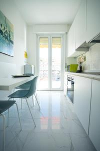 a white kitchen with a table and a chair at MICKY HOUSE in Sanremo