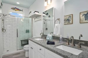 ein weißes Badezimmer mit zwei Waschbecken und einer Toilette in der Unterkunft Gulf Front - Mini Golf - Hot Tub - Family Friendly - ForeShore in Bolivar Peninsula + 38 Fotos