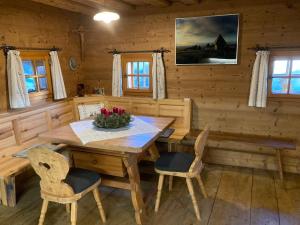 een houten eetkamer met een houten tafel en stoelen bij Gastkeusche Höss in Semriach