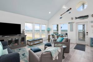 ein Wohnzimmer mit Sofas und einem Flachbildfernseher in der Unterkunft Gulf Front - Mini Golf - Hot Tub - Family Friendly - ForeShore in Bolivar Peninsula