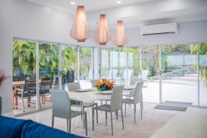 a dining room with a white table and chairs at Luxury Villa, Pool, Ocean view, 3 separate Villas one Property, 5 Bedrooms in Nazareth