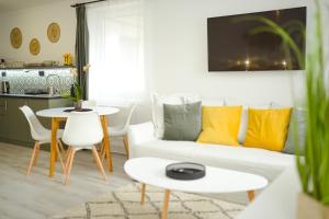 a living room with a white couch and a table at Raba92 Apartman House in Győr