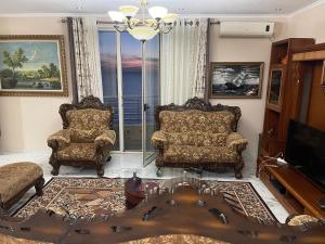 ein Wohnzimmer mit 2 Stühlen und einem TV in der Unterkunft LuxurySeaview Apartment in Durrës