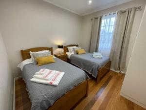 - 2 lits dans une petite chambre avec fenêtre dans l'établissement Casa da Grota, à Porto Moniz