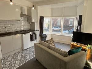 een woonkamer met een bank en een keuken bij Flat in Leamington Spa town centre in Leamington Spa