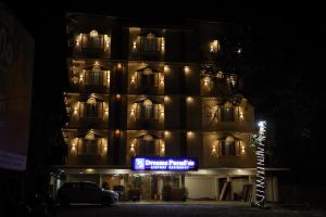 a building with a sign in front of it at night at DREAMS PARADISE AIRPORT RESIDENCY in Nedumbassery