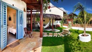 un jardin avec un hamac et une maison dans l'établissement Pousada Jeri, à Jericoacoara