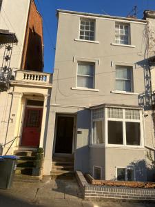 uma casa branca com uma porta vermelha numa rua em Flat in Leamington Spa town centre em Leamington Spa