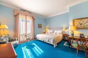 1 dormitorio con 1 cama, 1 mesa y 1 silla en Pestana Palace Lisboa Hotel & National Monument - The Leading Hotels of the World, en Lisboa