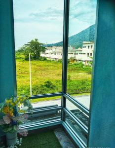 a window with a view of a field and buildings at SR KAMPAR HOMESTAY in Kampar