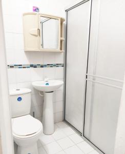 a bathroom with a toilet and a sink and a shower at Apartamentos Villa Leonor in Coveñas