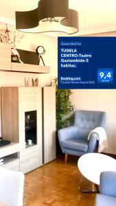 a living room with a blue chair and a fireplace at TUDELA CENTRO-Teatro Gaztambide-3 habitac. in Tudela