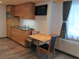 eine kleine Küche mit einem Holztisch und einem Schreibtisch in der Unterkunft "Studio Edelweiss" Spillstatthus in Grindelwald