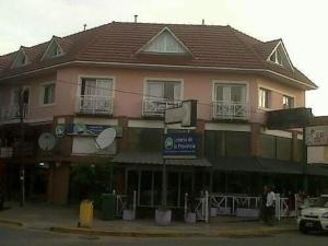 Un gran edificio rosa en una calle con en Playa Shaw 497, en Pinamar