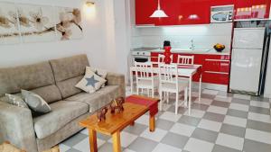 sala de estar con sofá, mesa y cocina en Apartamentos Montblanc Familidays 013, en Salou