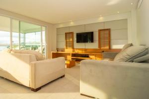 sala de estar con 2 sofás y TV en Vistar Mar Privilegiada em Jurerê, 3 suítes P1364, en Florianópolis