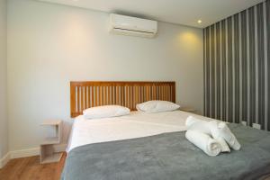 1 dormitorio con 1 cama grande con sábanas blancas en Vistar Mar Privilegiada em Jurerê, 3 suítes P1364, en Florianópolis