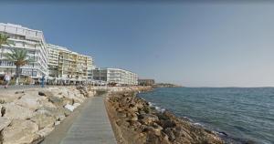 una playa con algunas rocas y edificios y el agua en Apartamentos Montblanc Familidays 013, en Salou