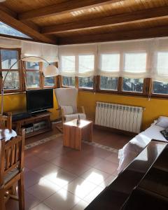 sala de estar con TV, sofá y mesa en Casa Laudina y Armando en Brañella