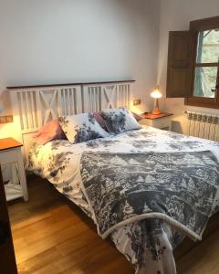 1 dormitorio con 1 cama con edredón blanco y negro en Casa Laudina y Armando en Brañella