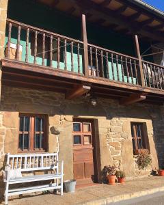 - un bâtiment avec un balcon et un banc devant dans l'établissement Casa Laudina y Armando, à Brañella