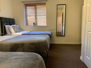 a bedroom with two beds and a mirror and a window at House - 10min to City Centre - Sleeps 4 - Parking in Birmingham